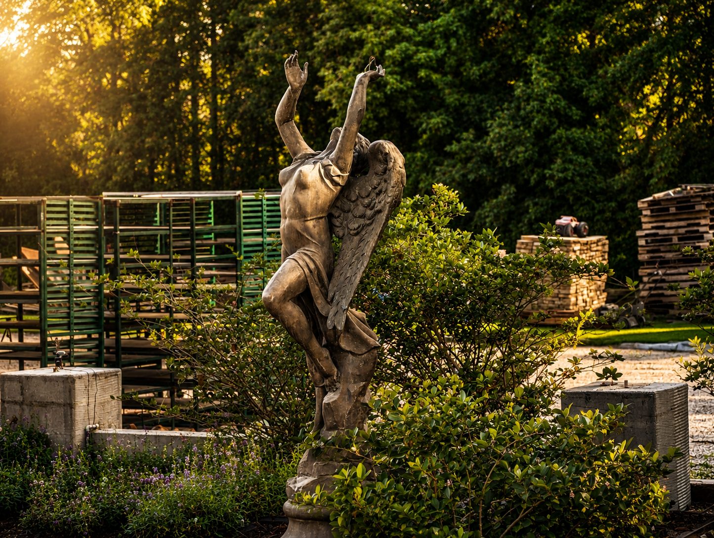 The Rain Lady statue reaching to the sky at golden hour, the working nursery behind her